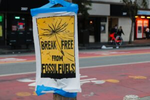 Sign on light post declaring humans break free from fossil fuel use